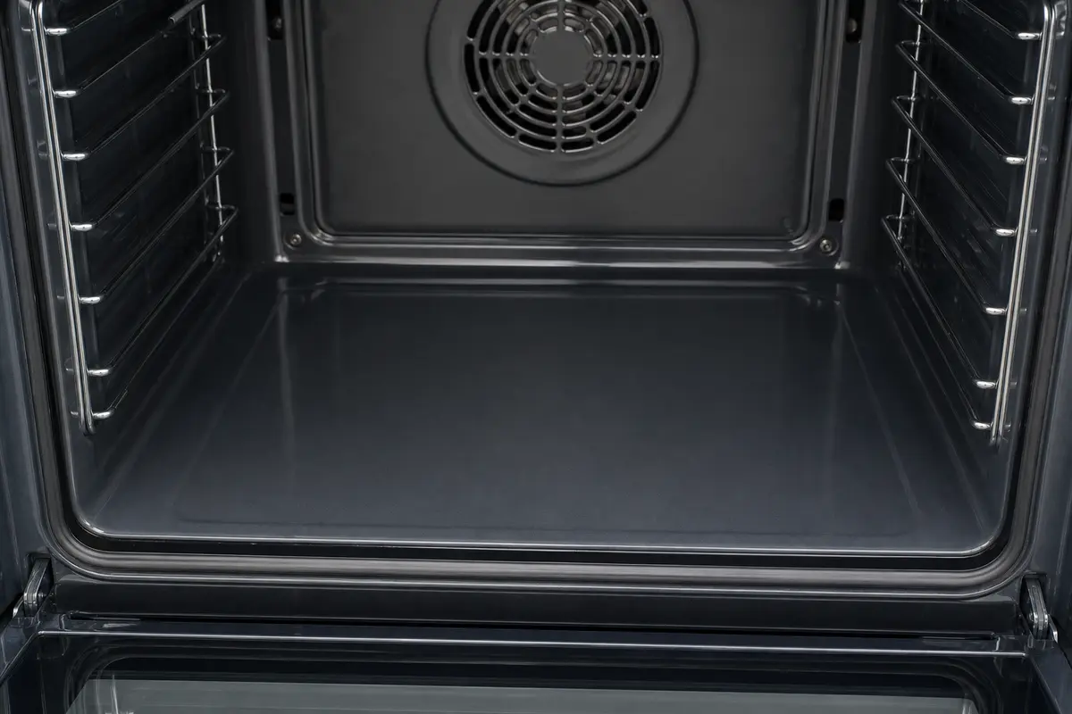 Smooth lower oven floor with no exposed bake element in an electric oven
