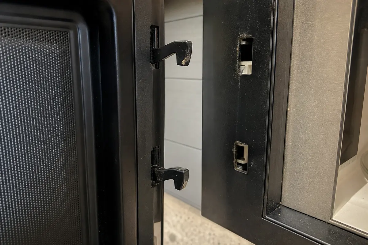 Microwave door latch hooks and latch openings inspected for misalignment