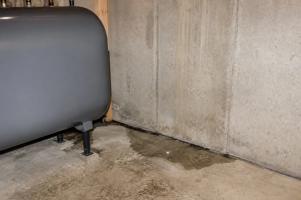 Clear water near a basement heating oil tank area and foundation seam