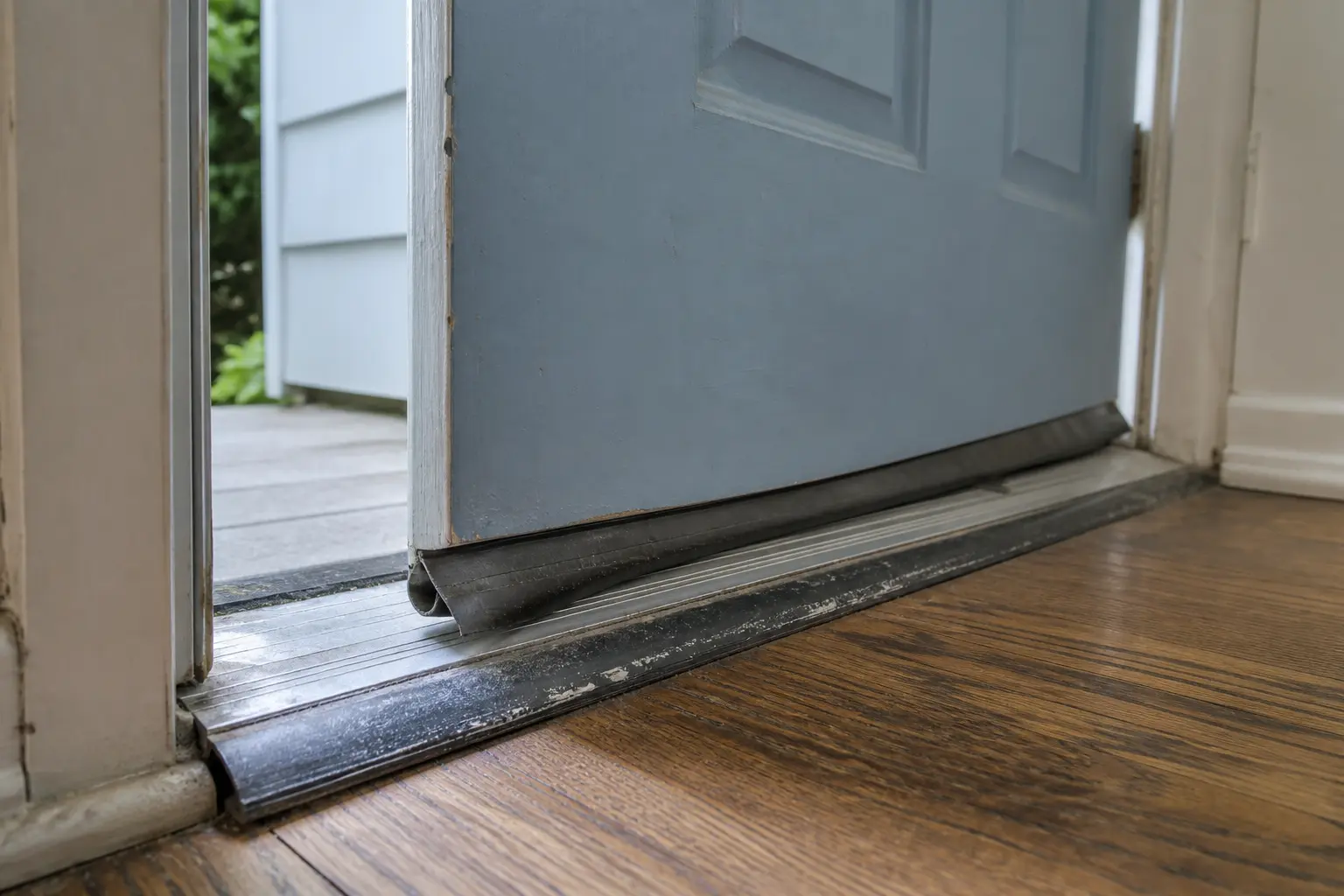 Door sweep folded against threshold causing bottom drag
