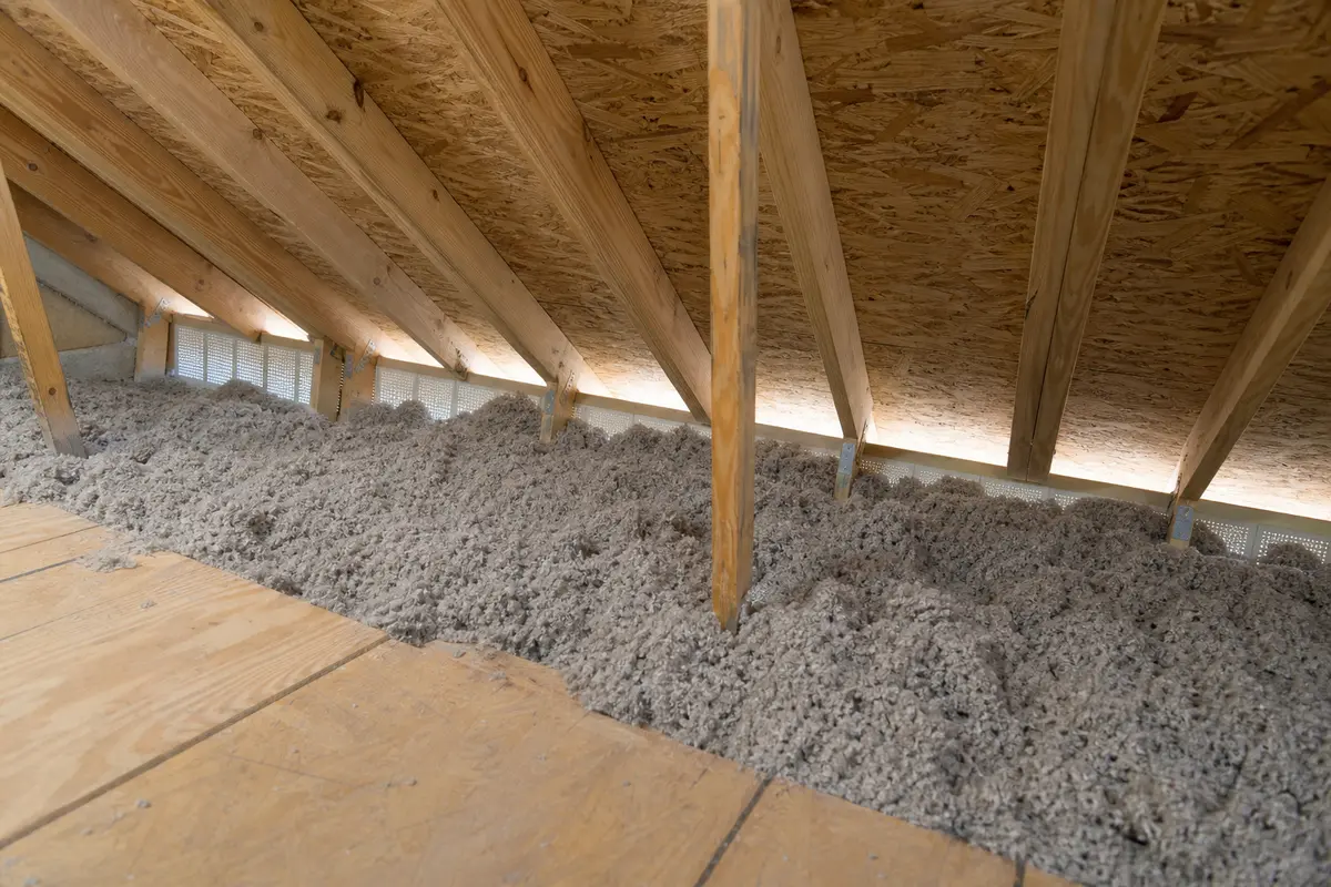 Attic eave overview with loose fill insulation near the soffit intake area