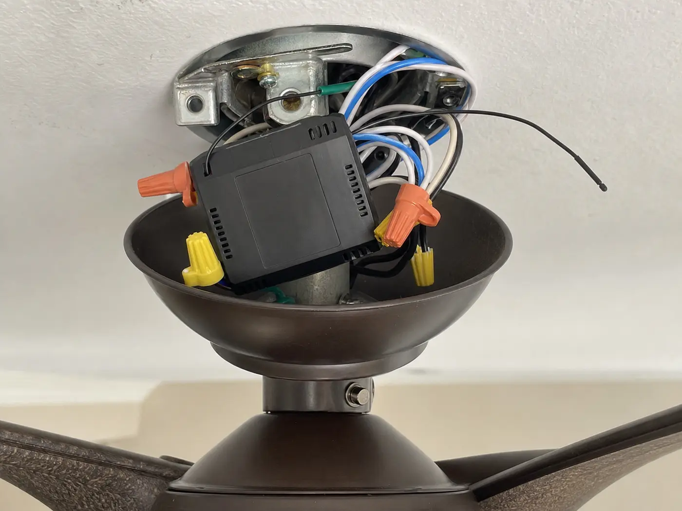 Ceiling fan canopy opened to show the remote receiver module and wire connectors
