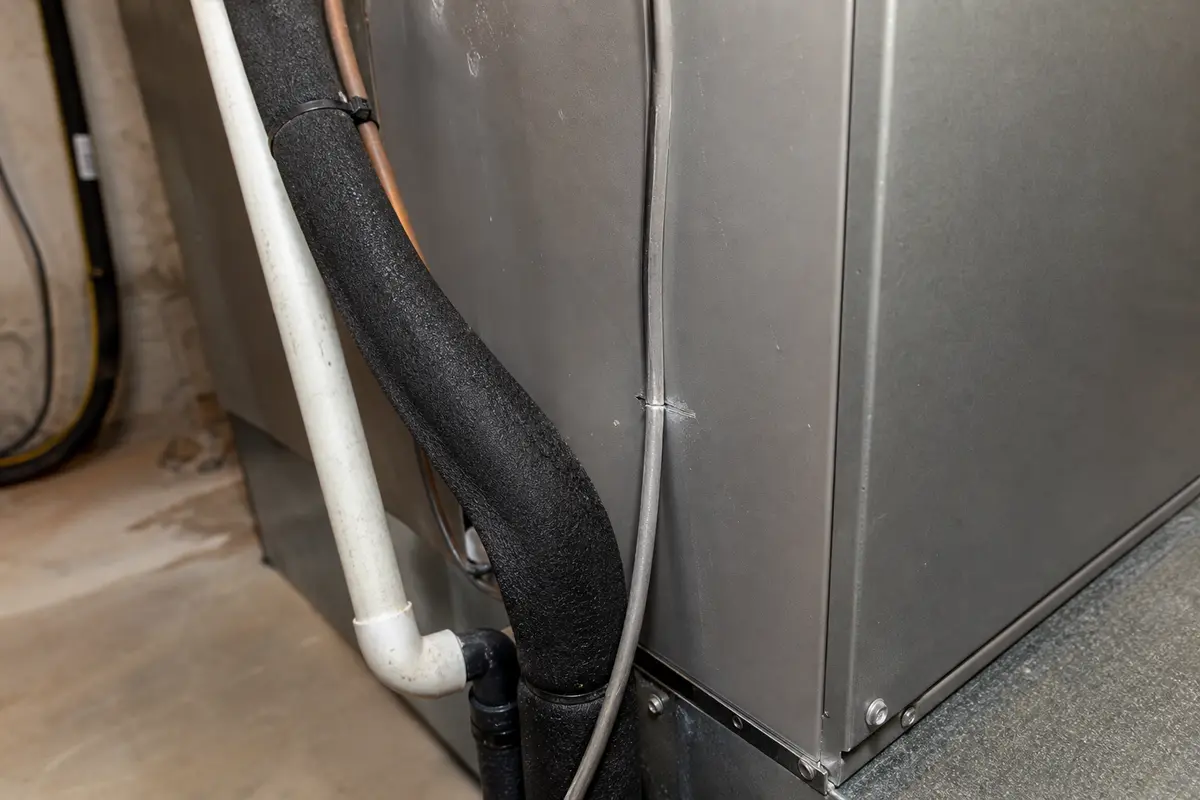 Condensate tubing and line insulation touching the air handler cabinet where vibration can transfer