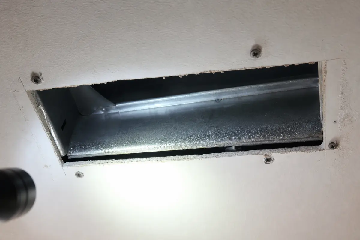 Condensation on a metal vent boot with a visible gap at the ceiling opening