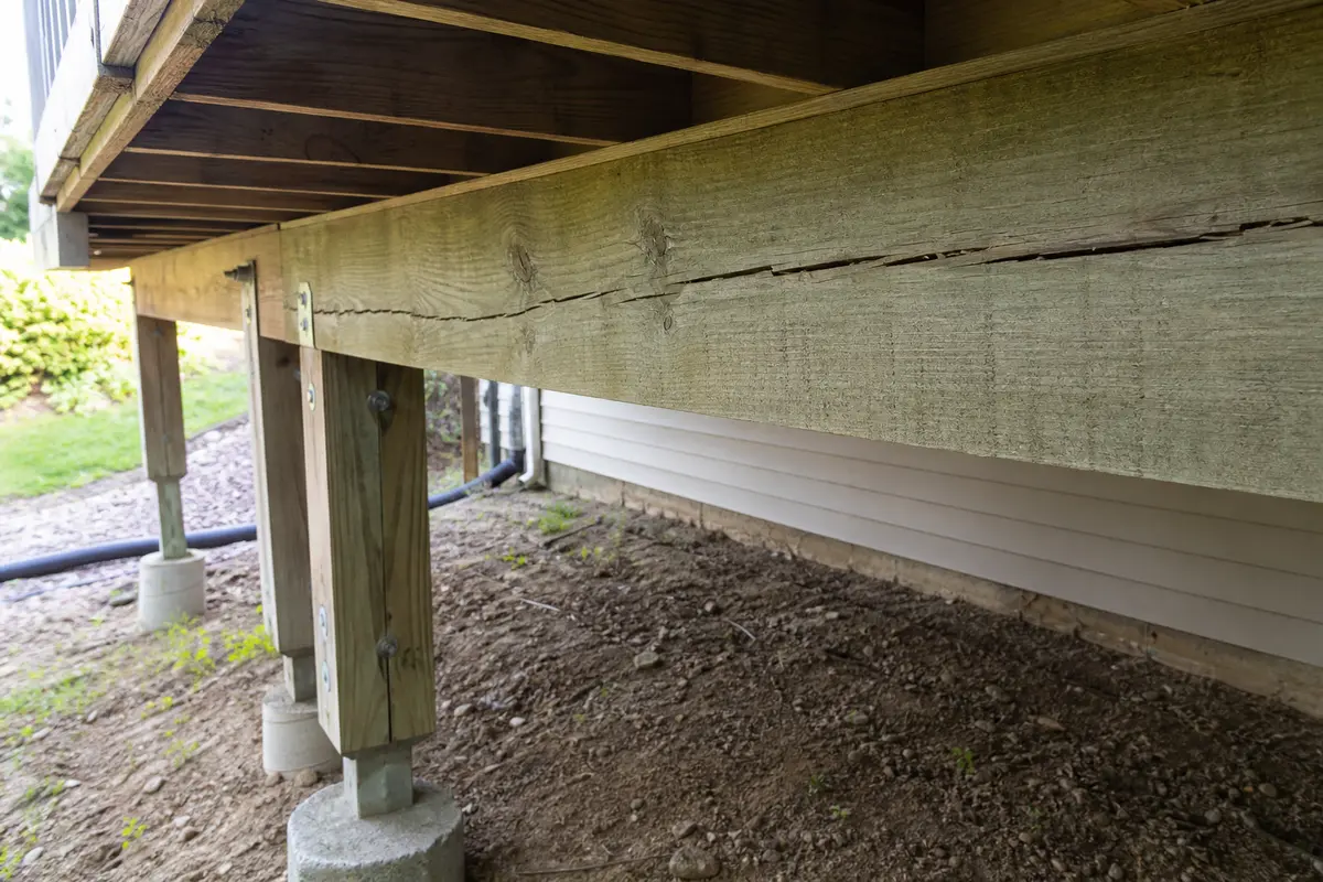Cracked deck beam viewed with posts, joists, and support path visible