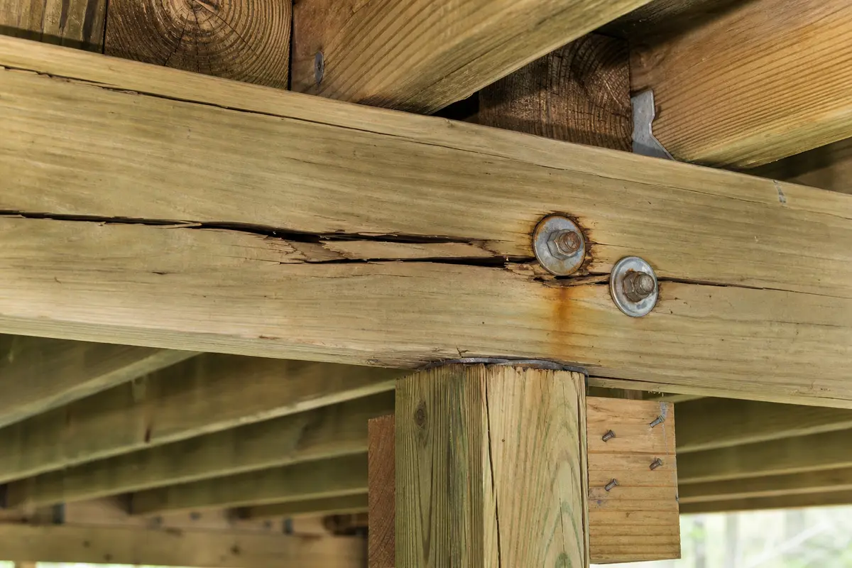 Cracked deck beam near bolt and post bearing checked for split movement