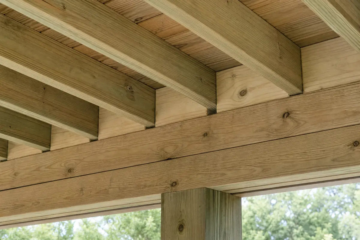 Close underside view of parallel deck joists bearing on a built-up beam with solid blocking fitted between joists