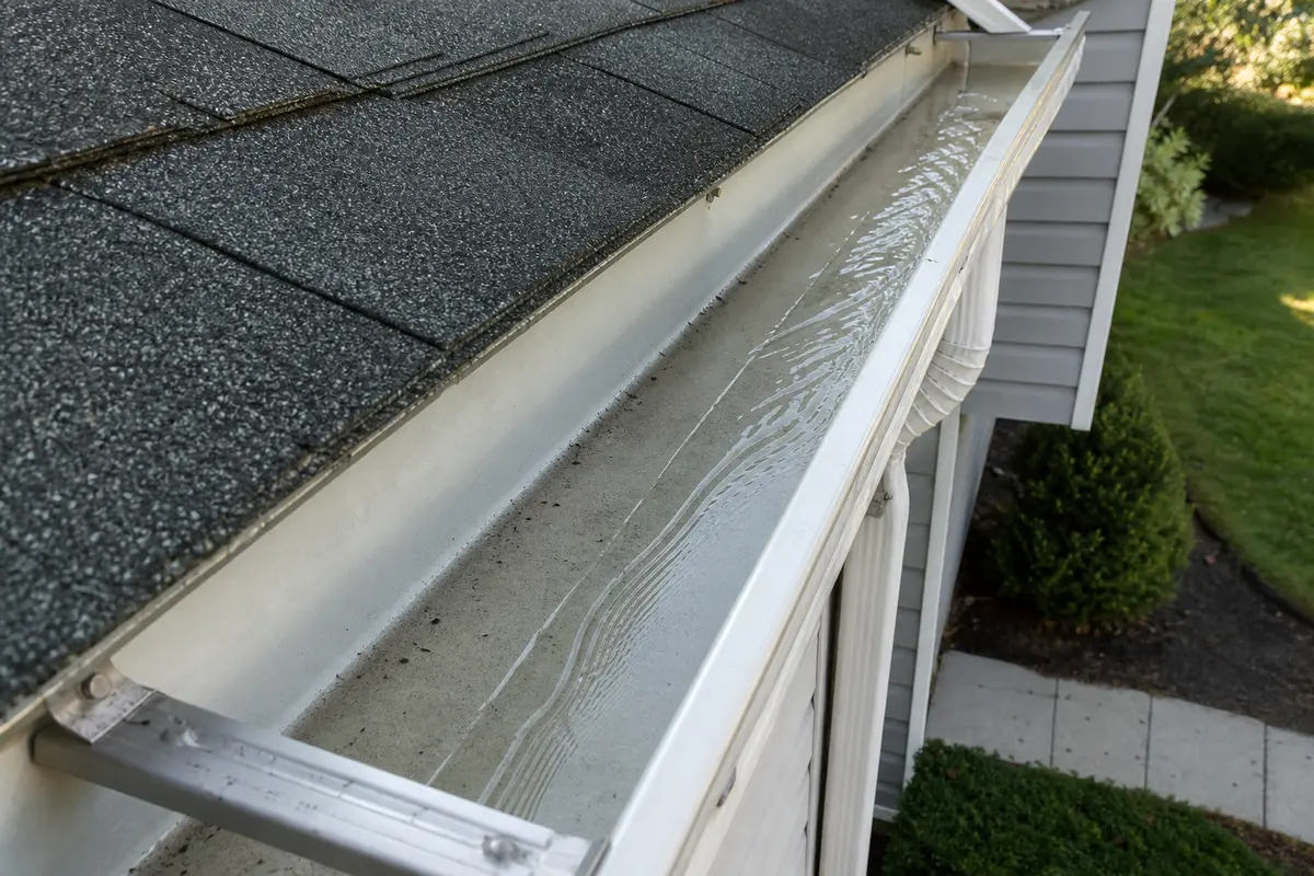 Clean gutter and downspout used as a normal drainage reference