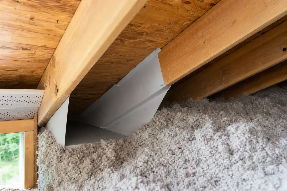 Attic ventilation baffle keeping eave airflow open near musty insulation