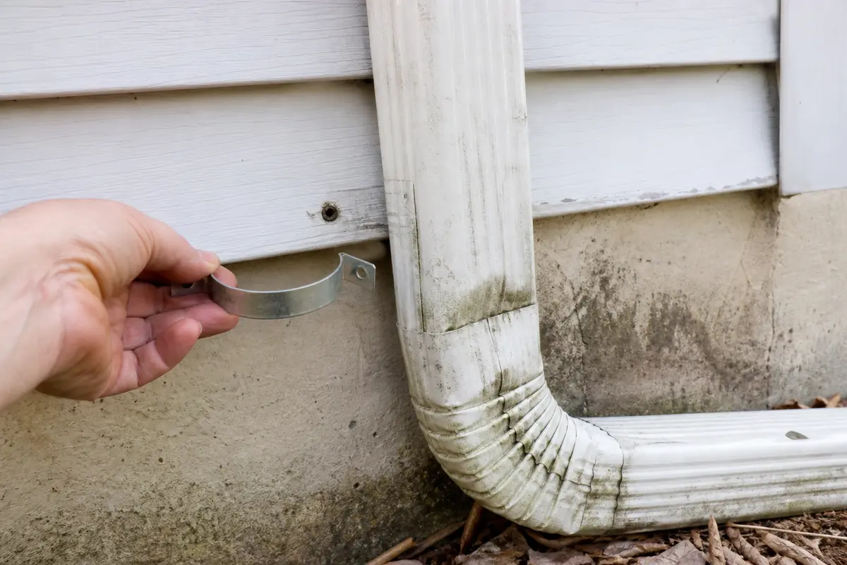 Replacement downspout strap for supporting a loose run near an elbow