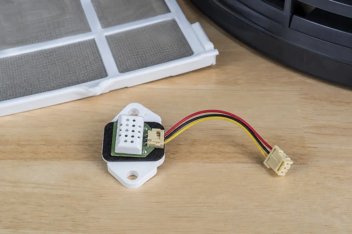 Dehumidifier humidity sensor assembly with connector beside a filter for model matching