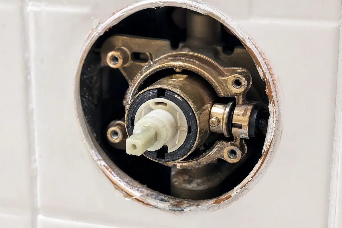 Bathtub shower valve limit stop exposed behind handle trim
