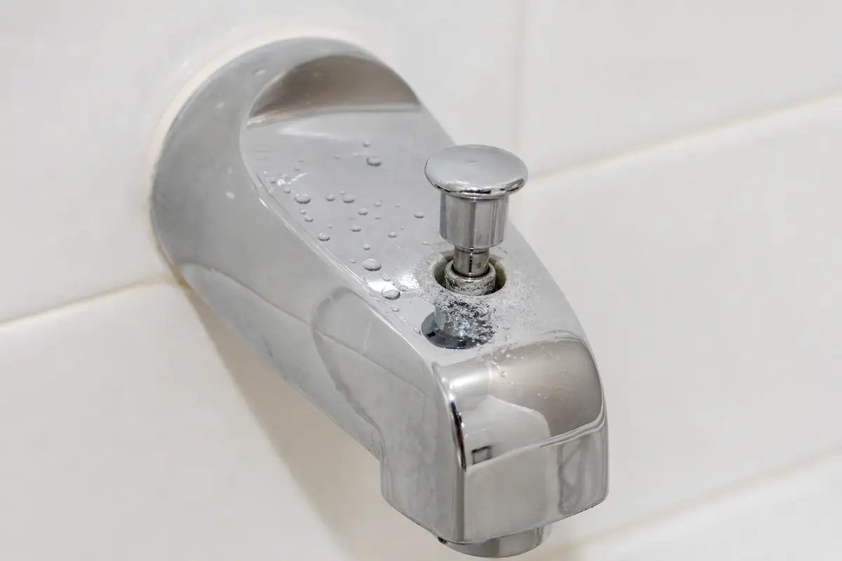 Closeup of a stuck pull-up diverter knob on a bathtub spout