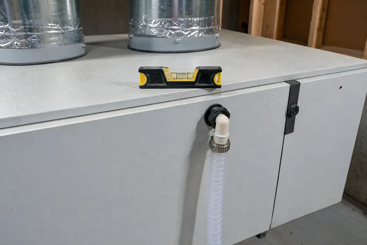Small torpedo level for checking HRV or ERV cabinet pitch toward the drain