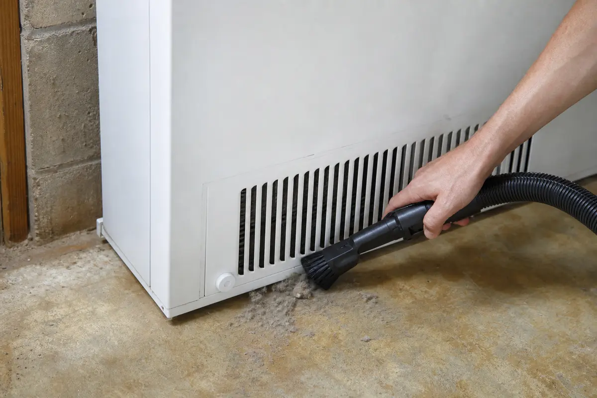Vacuum with brush attachment shown in the repair area for midea chest freezer alarm keeps beeping