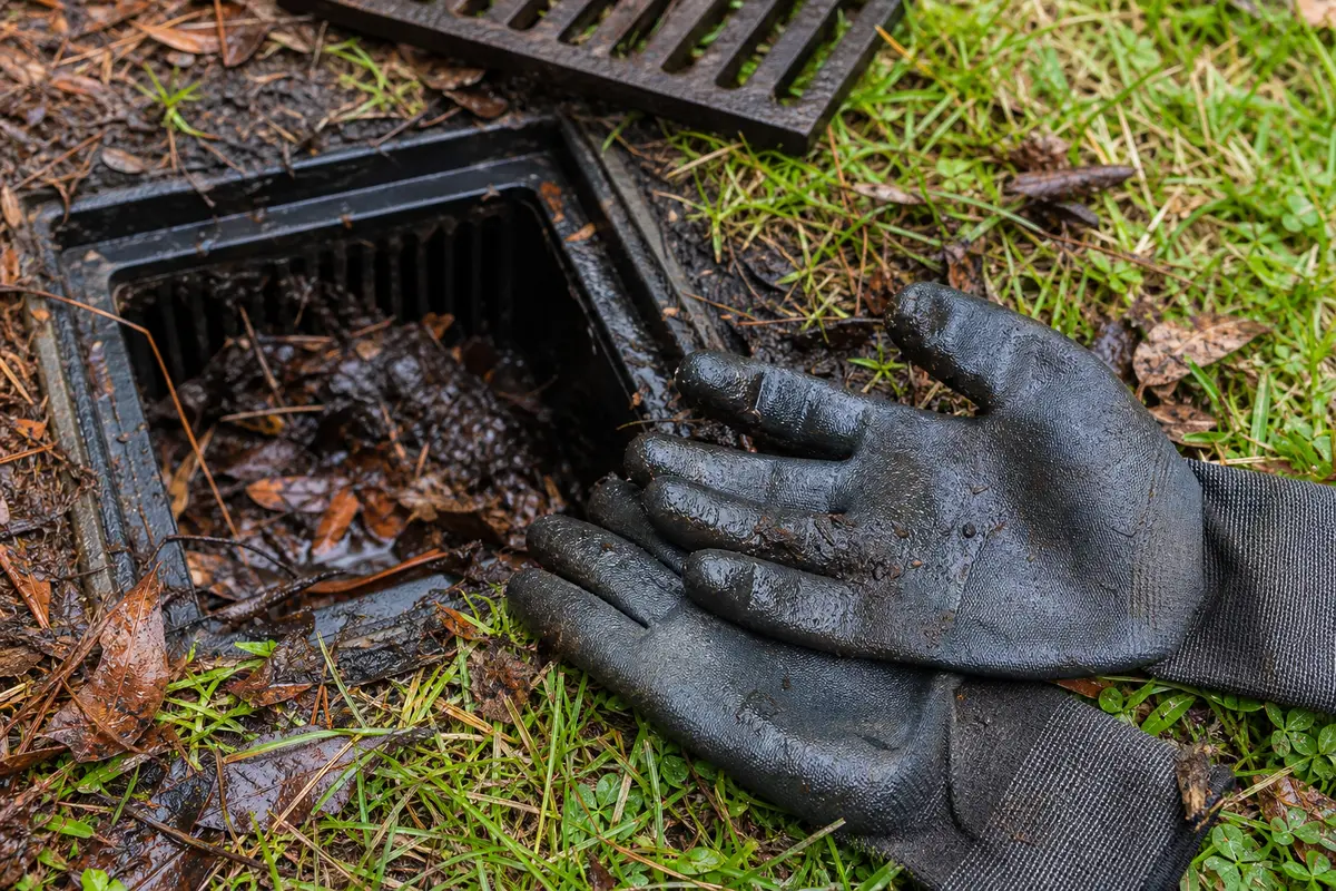 Waterproof work gloves for cleaning a clogged yard drain basin